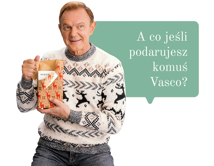 Cezary Pazura w świątecznym swetrze trzyma prezent i otwiera go, a w środku widać pudełko Vasco Translatora. W tle dymek z tekstem: A co jeśli podarujesz komuś Vasco?