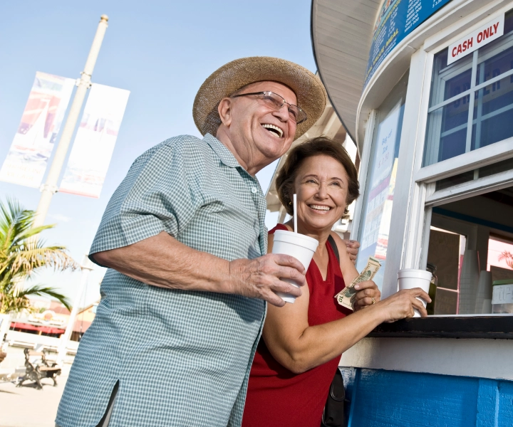 Uśmiechnięta starsza para zamawiająca napoje w kiosku.