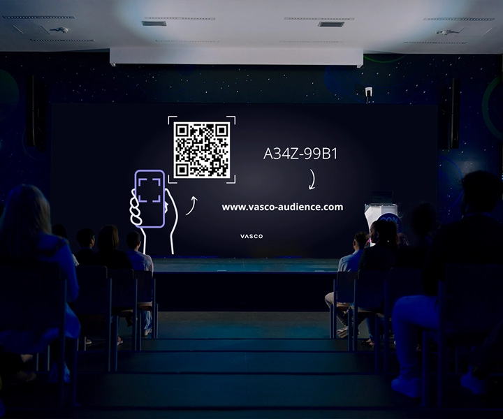 Na dużym ekranie w sali konferencyjnej wyświetlane są instrukcje „Dołącz do Vasco Audience”, zawierające wskazówki dla uczestników dotyczące dostępu do sesji.
